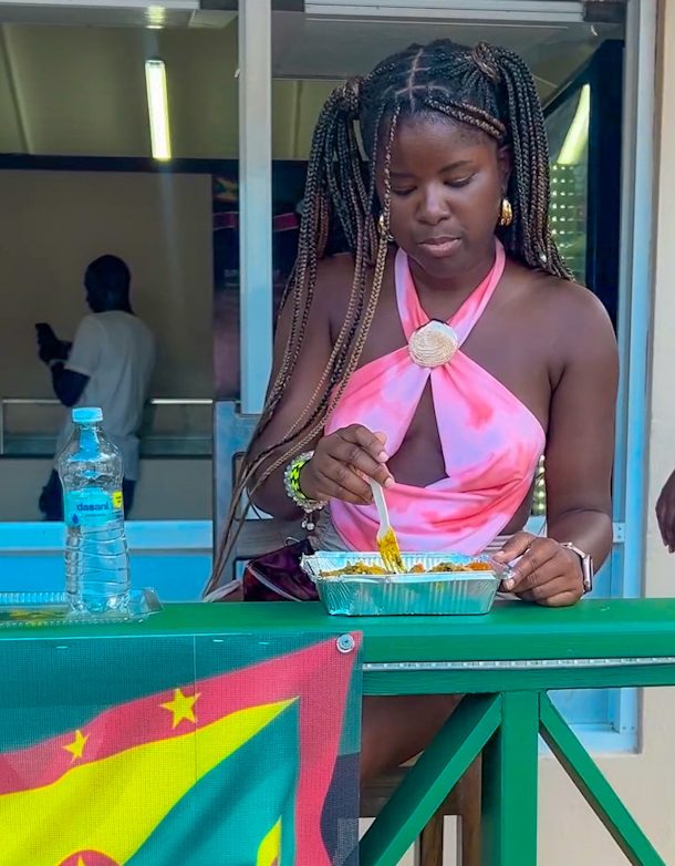 Ali enjoying Grenada's national dish, Oil Down outside a restaurant